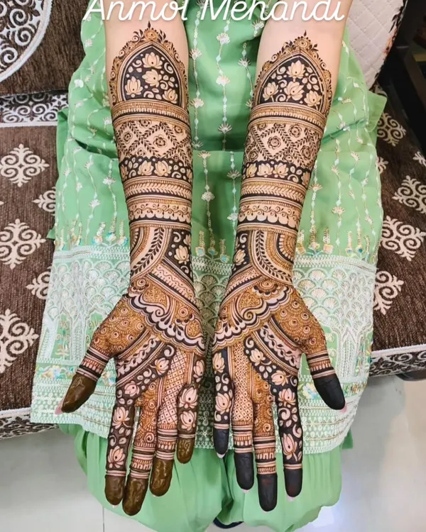 A beautiful example of a full-coverage design using geometric and floral patterns. The symmetry and clean lines create a very elegant and traditional bridal look.