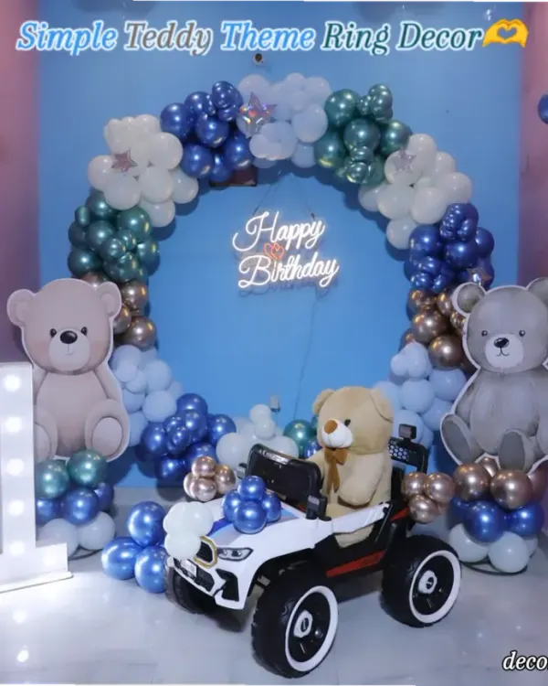 A beary special first birthday! This adorable teddy bear theme features a blue backdrop with a balloon ring, cute teddy bear cutouts, a marquee number '1', and even a teddy driving a toy car. It's a sweet and classic theme for a little one's big day.
