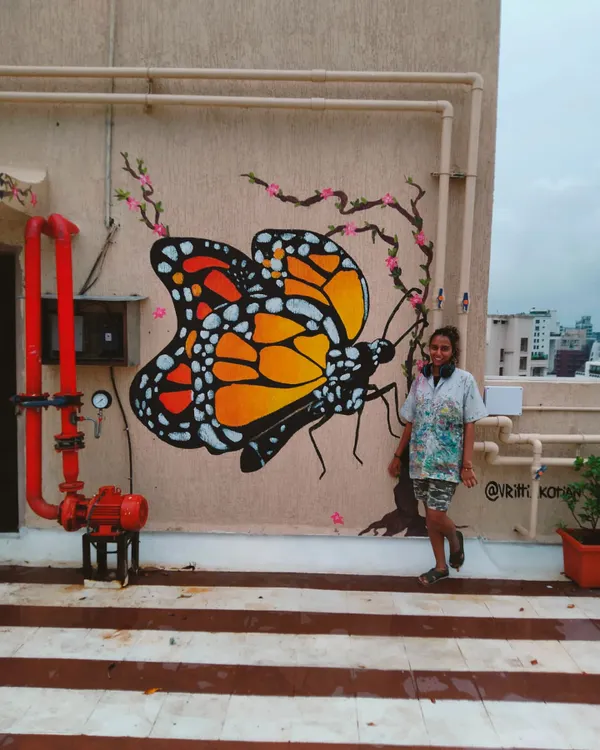 And just when they thought they could keep the caterpillar inside a cage, she began to fly again. Me standing proudly next to the finished monarch butterfly mural on a building terrace in Bandra.