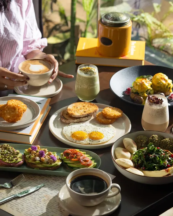 A full brunch spread with coffee, eggs, avocado toast, and more. This shot captures the ideal weekend brunch experience.