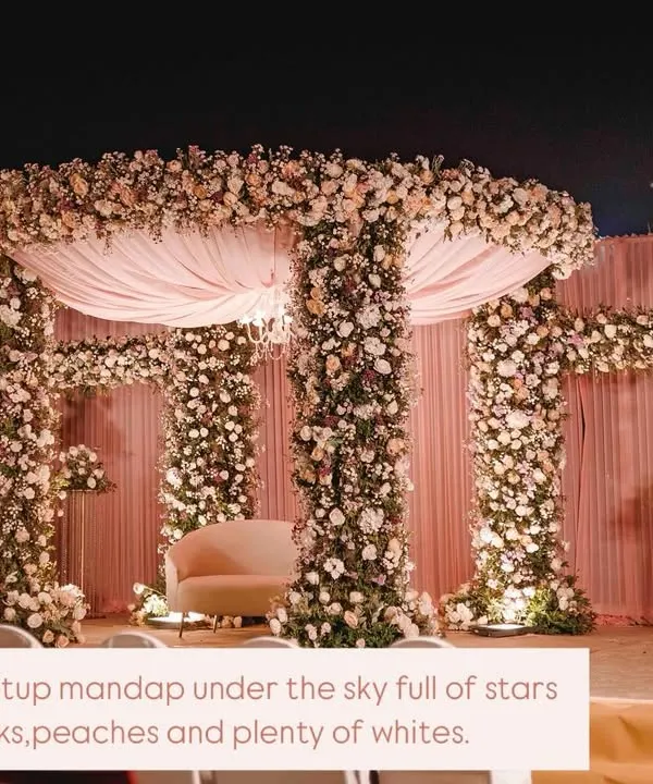 A beautifully setup mandap under a sky full of stars. We used hues of pinks, peaches, and plenty of whites to create this romantic, open-air floral mandap for a truly magical wedding ceremony.
