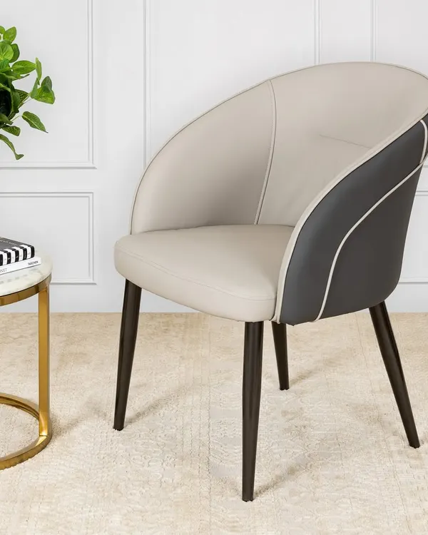 This chair is the definition of quiet luxury. Upholstered in smooth cream and dark grey leather with sculptural curves and elegant piping, it’s the kind of piece that belongs in a well-curated, modern space.