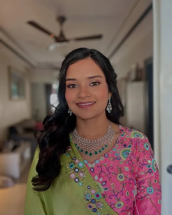 A perfect example of a radiant Haldi ceremony look. The makeup is minimal and fresh, letting the bride's natural glow shine through, complemented by soft curls.