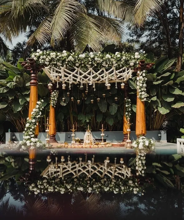 A breathtaking mandap design reflected in the water, creating a serene and magical setting for a wedding ceremony at Farmhouse Collective.
