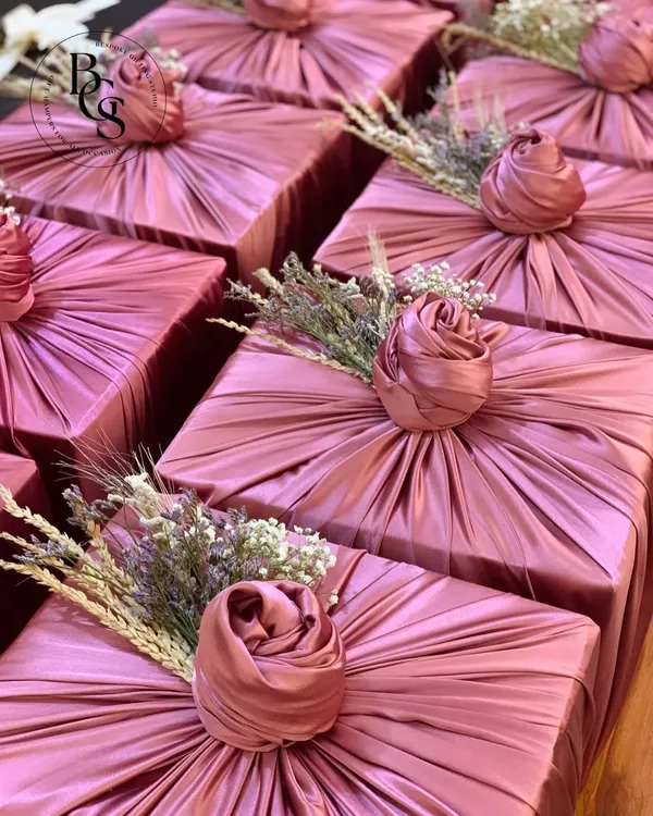 The unboxing experience is paramount. Here, I used a beautiful dusty rose fabric to wrap these gifts, creating a soft, luxurious texture. The wrapping is finished with a delicate floral sprig, transforming a simple box into an elegant and memorable present before it's even opened.