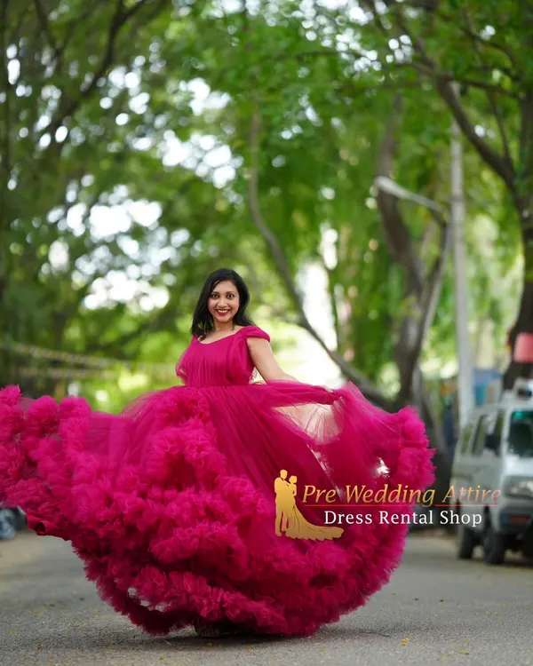 This magenta ruffled gown creates a beautiful, full silhouette, perfect for a maternity shoot with a touch of magic. The twirling motion shows off the incredible volume and flow of the layered tulle skirt.
