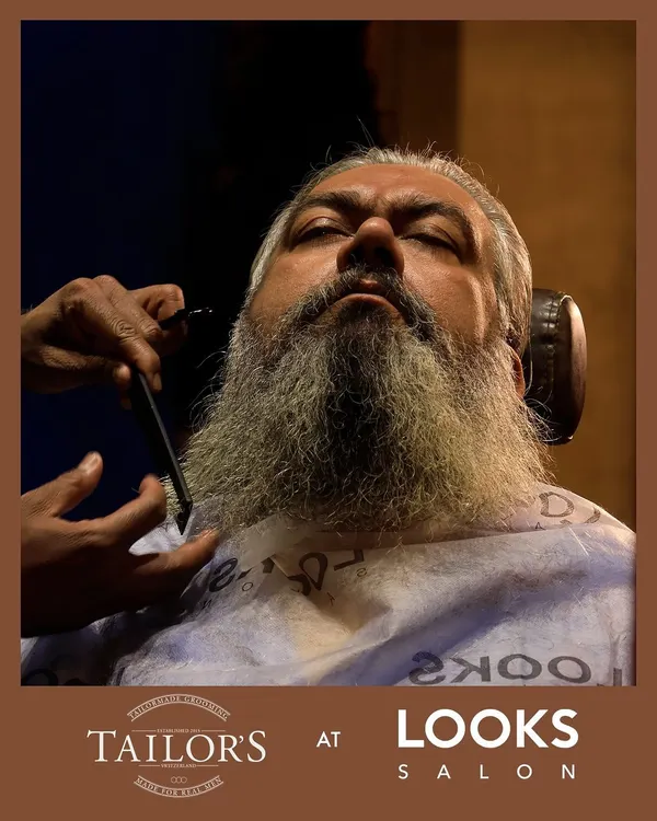 Even a long, full beard requires expert care to look its best. Here, my specialist is performing a precision trim with a straight razor, carefully shaping the beard to maintain its length while ensuring clean lines and a healthy appearance.
