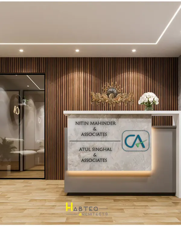 The reception area is the first thing a client sees, and for this CA office in New Delhi, I designed a space that is both impressive and professional. The custom desk prominently features the firm's branding, set against a warm, vertically-paneled wood wall.