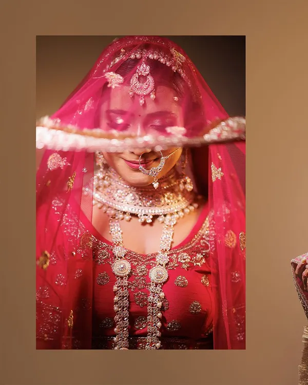 A classic, elegant bridal portrait. We use a simple background and soft lighting to draw all attention to the bride, her intricate jewelry, and the delicate veil covering her eyes.