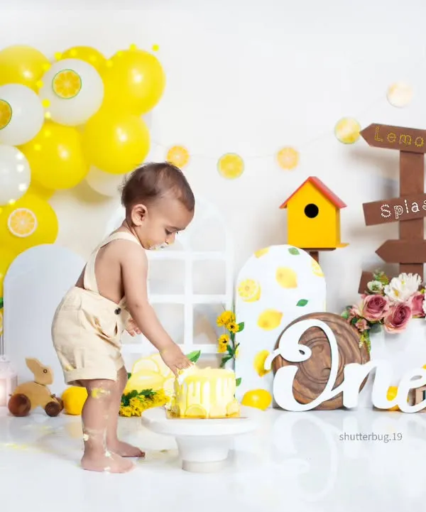 A little one getting his first taste of birthday cake during our bright and cheerful lemonade-themed cake smash.