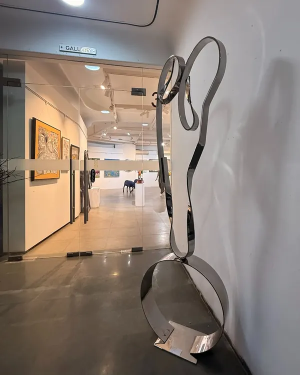 "The Bond," a freestanding sculpture in stainless steel, seen here at the entrance to a gallery. Its form is an abstract representation of a mother and child's embrace.