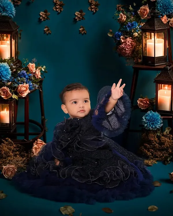 This is one of my favorite creative concepts. I designed this enchanting, moody setup in my studio with candle-lit lanterns and rich blue florals to create a truly magical portrait for this little one.