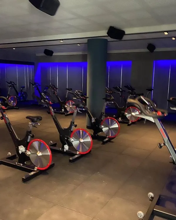 For the Chakra spinning studio, we created a high-energy, immersive environment. The use of dynamic blue ambient lighting against dark walls and industrial-style flooring sets a motivational tone for intense workouts.