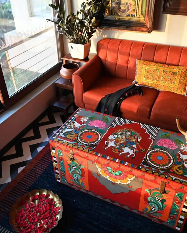 A restored vintage trunk serves as a stunning coffee table, its surface alive with hand-painted Kalamkari motifs. This piece shows how functional furniture can also be a collectible work of art, bringing heritage and color into a modern living space.