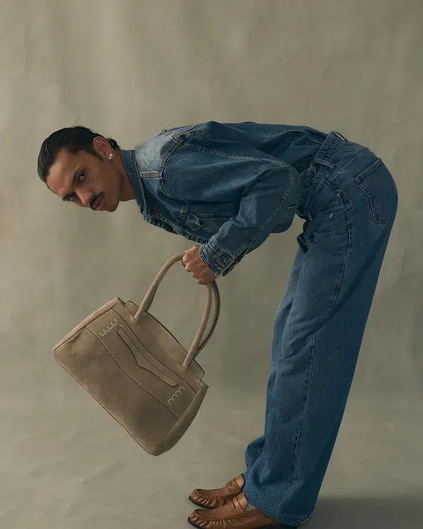 A model showcasing the structured style of our Penny Carryall in a soft, neutral suede. It’s a modern classic designed for those who appreciate clean lines and subtle details.