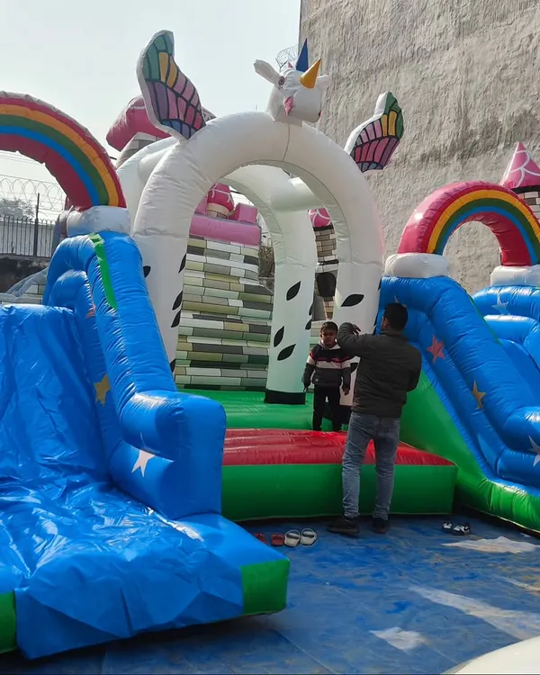 A beautiful unicorn-themed inflatable play area. This new model features a large unicorn archway, rainbows, and two slides, perfect for magical-themed events.