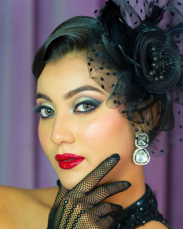 A close-up of a vintage-inspired editorial look. The sharp, smoked-out eyes, classic red lip, and flawless skin are key elements of this high-fashion style.