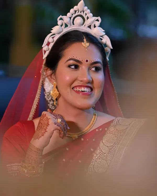 The timeless elegance of a Bengali bride. For Piyashi, who was nervous about makeup, I created a second-skin look with simple kolka designs and soft gold hues on the eyelids to complement her red Banarasi saree and traditional mukut.