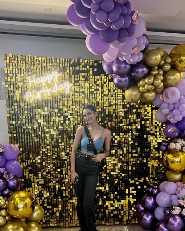 A stunning golden sequin wall we set up for a client's birthday. Framed by a rich purple and gold balloon arrangement and a custom neon sign, this backdrop is designed to make a statement.