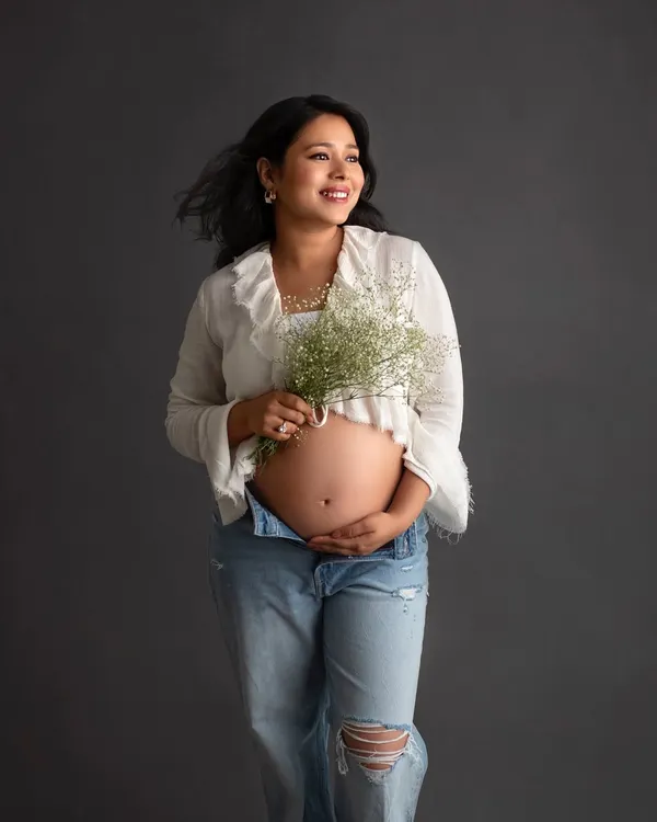 I absolutely love this breezy and carefree look. A simple white top, unbuttoned jeans, and a bouquet of baby's breath create such a fresh and modern maternity portrait.