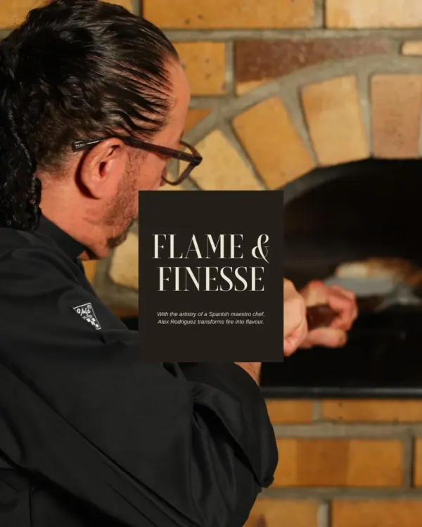 This image, titled "Flame & Finesse," captures me at the wood-fired oven. The fire is an essential tool in my kitchen, bringing rustic flavour and tradition to our dishes.