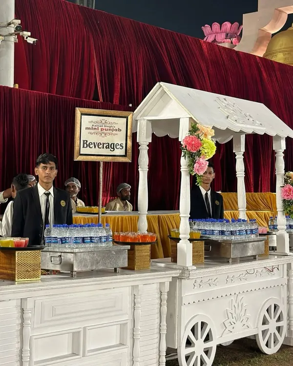 Our beverage carts are designed to be both functional and beautiful. This charming white cart, staffed by our professional servers, offers a refreshing welcome to guests at an outdoor event.