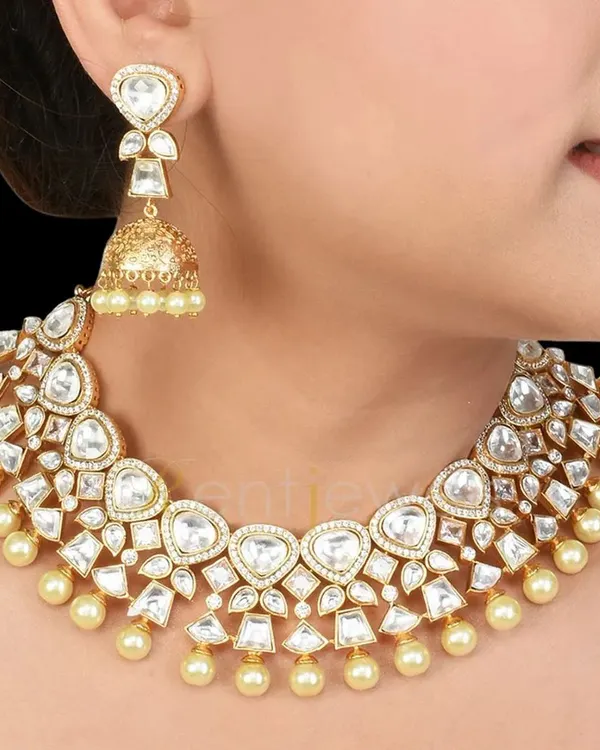 A timeless classic, this Kundan choker with delicate pearls and matching jhumka earrings is perfect for any wedding event. It adds grace and elegance without being overwhelming.