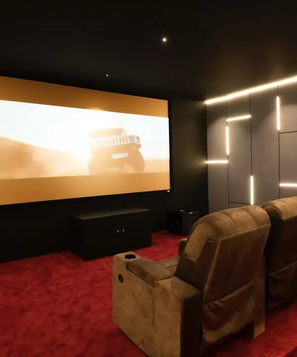 A view from the back of a 9.1.4 luxury home cinema in Thirunagar, Madurai. The massive 150-inch Elite Screen is perfectly paired with an Optoma projector, delivering a crystal-clear 8K picture.