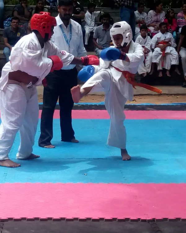 A moment of perfect execution. A student lands a kick in a youth competition. This is the result of countless hours of practice in the dojo.