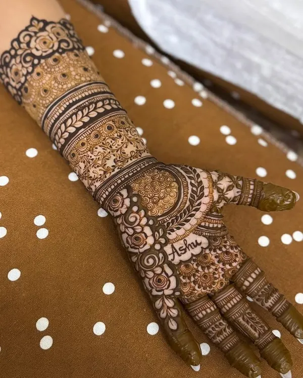 A perfect example of personalization, with the name 'Ashu' elegantly written into the palm of this detailed engagement henna.