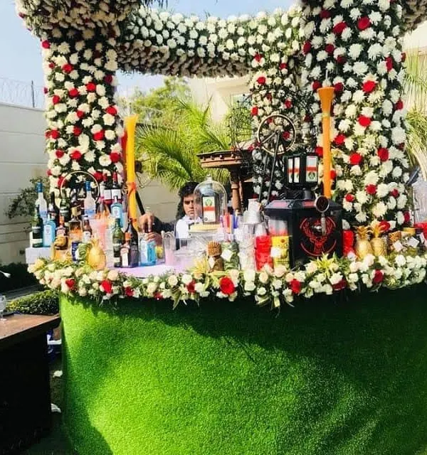 For this daytime wedding event, I created a spectacular floral bar counter. The structure is densely packed with fresh white and red roses, creating a luxurious and unforgettable centerpiece for guests.