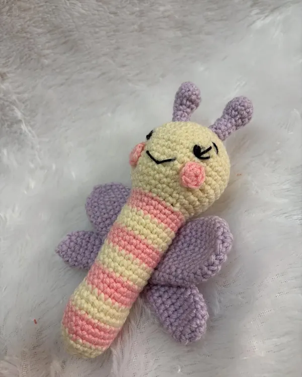 A gentle and colorful butterfly baby rattle. The wings and striped body are designed to be visually stimulating for a newborn.