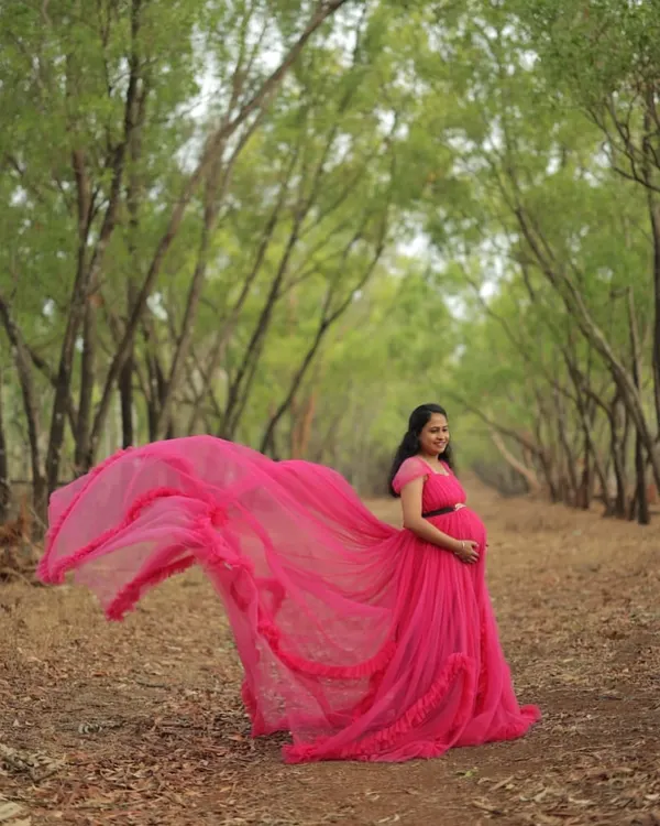 This is what I mean by a dramatic trail. This vibrant pink maternity gown is designed to create breathtaking, flowing shots in any outdoor setting, like this beautiful forest path. The lightweight tulle fabric catches the air perfectly for those epic, swirling photos.