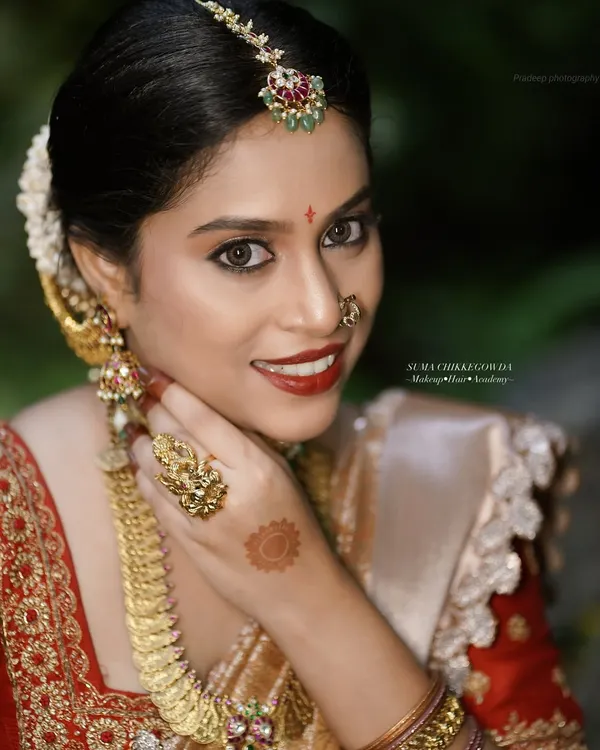 This is the quintessential South Indian muhurtham look that every bride dreams of. It features a flawless, long-lasting base that feels light on the skin, paired with classic gold temple jewelry and a bold red lip. This is the level of perfection we teach and deliver.