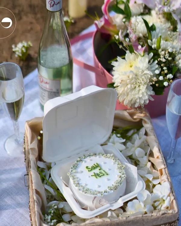 Crafting the perfect beachside proposal starts with personal touches. A custom "Say Yes" cake, chilled champagne, and a beautiful floral arrangement create a simple yet unforgettable setting for a magical question.