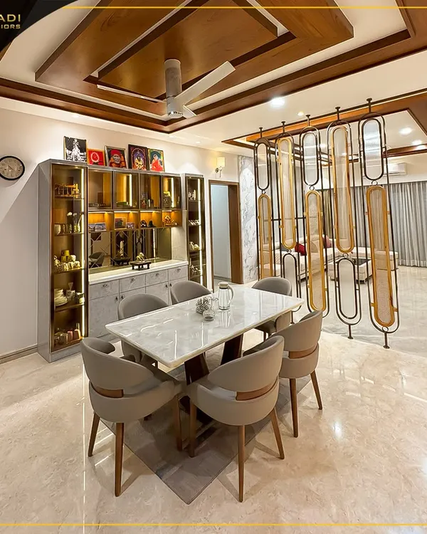 An open-plan living and dining area designed for seamless interaction. The space features a marble-top dining table, a glass-encased crockery unit, and a decorative partition that elegantly separates the dining area from the living room.