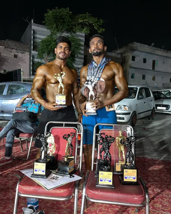 Two of my students with their hard-earned trophies. Their condition and posing reflect countless hours of dedicated work in the gym and kitchen.