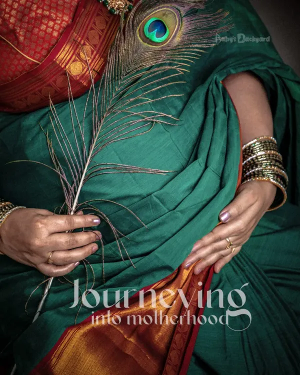 Journeying into motherhood, wrapped in the elegance of a traditional green saree. This close-up shot with a peacock feather beautifully symbolizes grace and new beginnings.