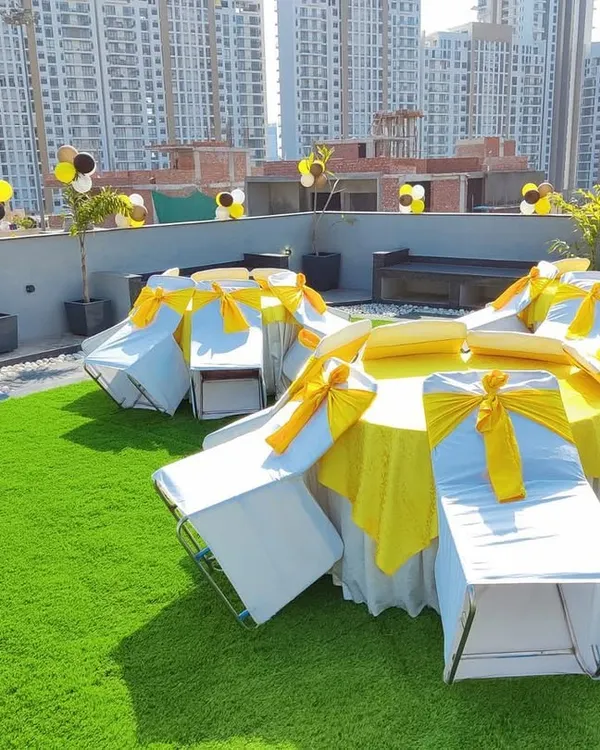 This was a birthday celebration on a rooftop. I provided the complete seating arrangement with tables and chairs, using a yellow and black color theme for the covers and balloons.