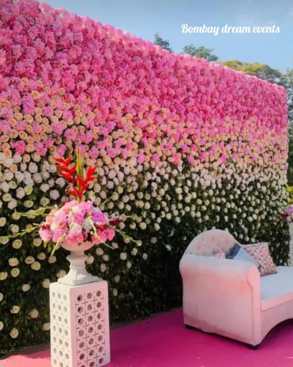 A breathtaking floral wall that serves as a stunning photo backdrop. This wall features an ombre effect with pink, white, and green flowers, perfect for a baby shower, naming ceremony, or engagement.