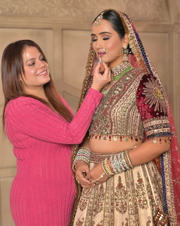 A behind-the-scenes moment where I am giving the final touch-ups to the bride's lips. It's these small details that perfect the entire look.
