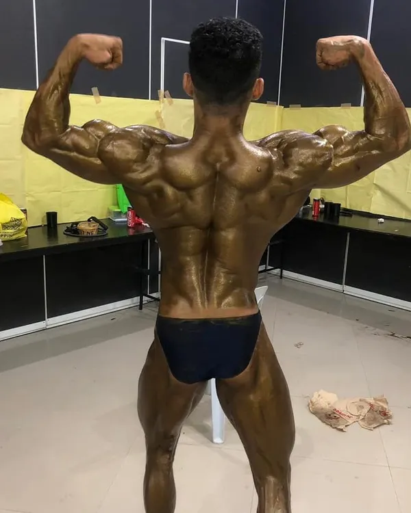 A back double biceps pose from backstage at the Mr. Asia 2019 competition. This pose is critical for showing back width, density, and hamstring definition.