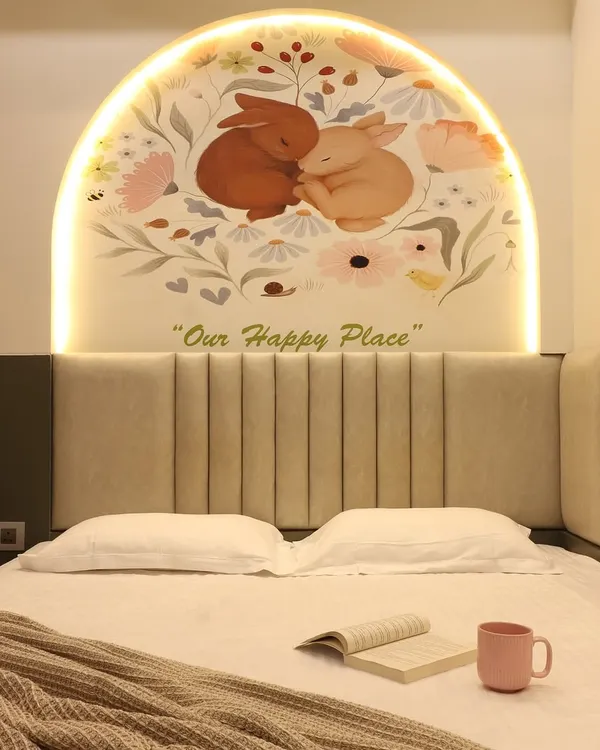 A charming bedroom design featuring a custom arched mural with integrated backlighting above the bed. The soft, upholstered headboard and the "Our Happy Place" text create a personalized and comforting atmosphere.