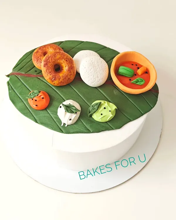 A unique cake designed to look like a traditional South Indian meal served on a banana leaf. Every element, from the idli and vada to the sambar and chutneys, is handcrafted from edible fondant.