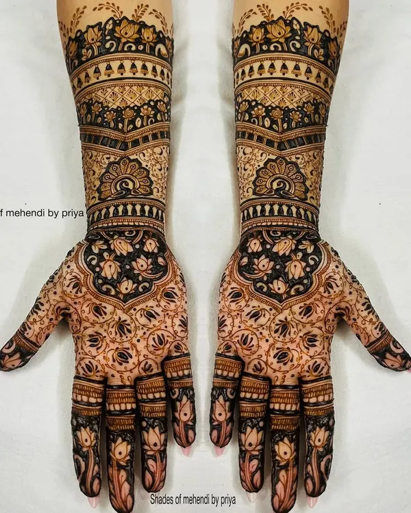 This is the kind of full bridal mehendi I love to create. The design is perfectly symmetrical, featuring delicate lotus motifs on the fingers and a dense, traditional pattern that extends up the arm for a truly stunning bridal look.