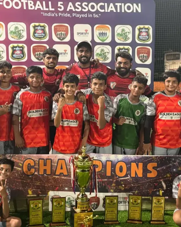 This is what we play for. Our team stands proud as champions, surrounded by coaches and trophies after a hard-fought tournament. This moment represents the dedication and team spirit we build at Golden Eagles.