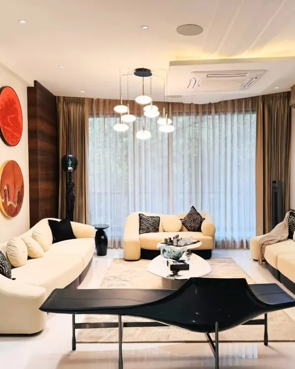 This living room combines classic elegance with modern comfort. The curved sofas, statement artwork, and layered lighting create a sophisticated yet welcoming space for hosting guests.