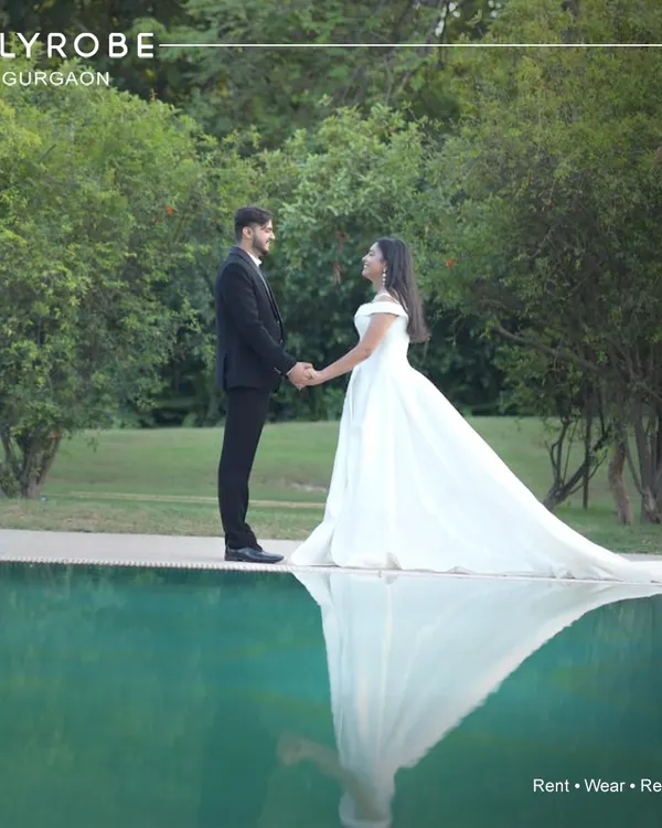 Create magical, reflective moments during your pre-wedding shoot. This couple looks serene by the pool, with him in a classic black suit and her in a beautiful white rental gown.