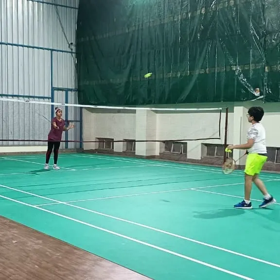 A young player practices his swing during a kids' badminton coaching session. We focus on building strong fundamentals and proper technique from the very first day.