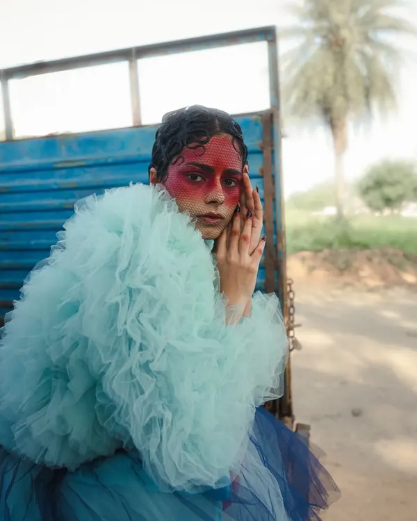 A shot from my 'Serpent' series, where we used voluminous tulle and bold, theatrical makeup to explore themes of transformation and grace. The juxtaposition of the delicate fabric with the rustic truck creates a compelling visual contrast.